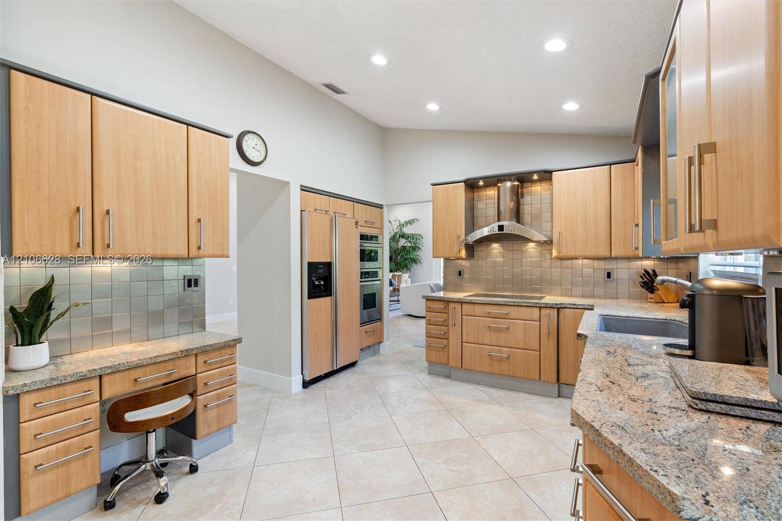 7259 Via Palomar, Boca Raton, FL 33433 Kitchen featuring light-tone cabinetry, stone countertops, square-tile backsplash, stainless steel appliances, and vaulted ceilings with recessed lighting