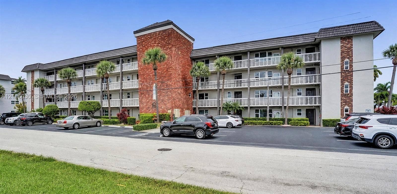 Multi-story exterior featuring a brick facade, stucco siding, and private railed balconies