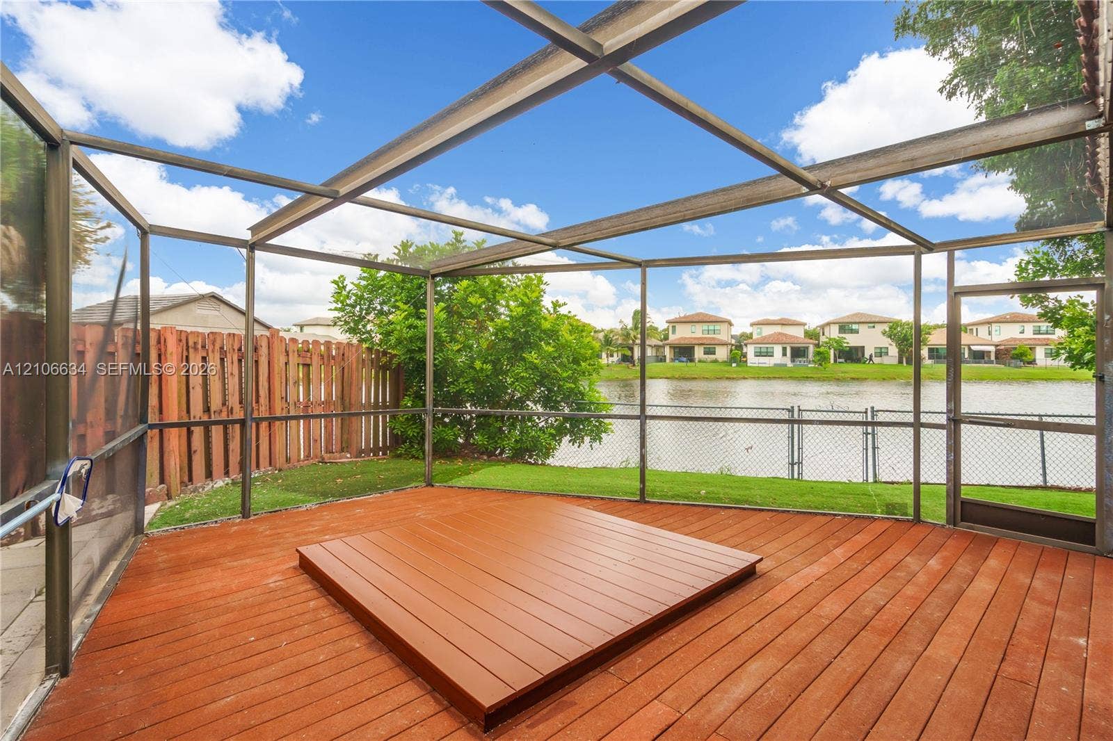 Screened-in patio featuring a raised deck where spa used to be. Screened enclosure, and waterfront perimeter
