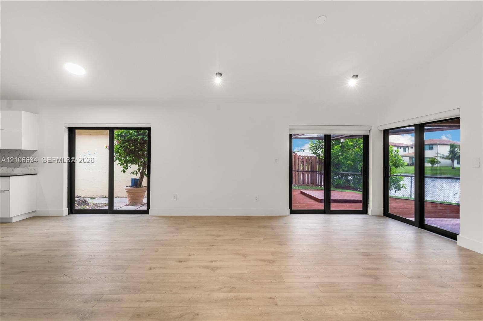 Open-concept interior, recessed lighting multiple sliding glass doors providing outdoor access