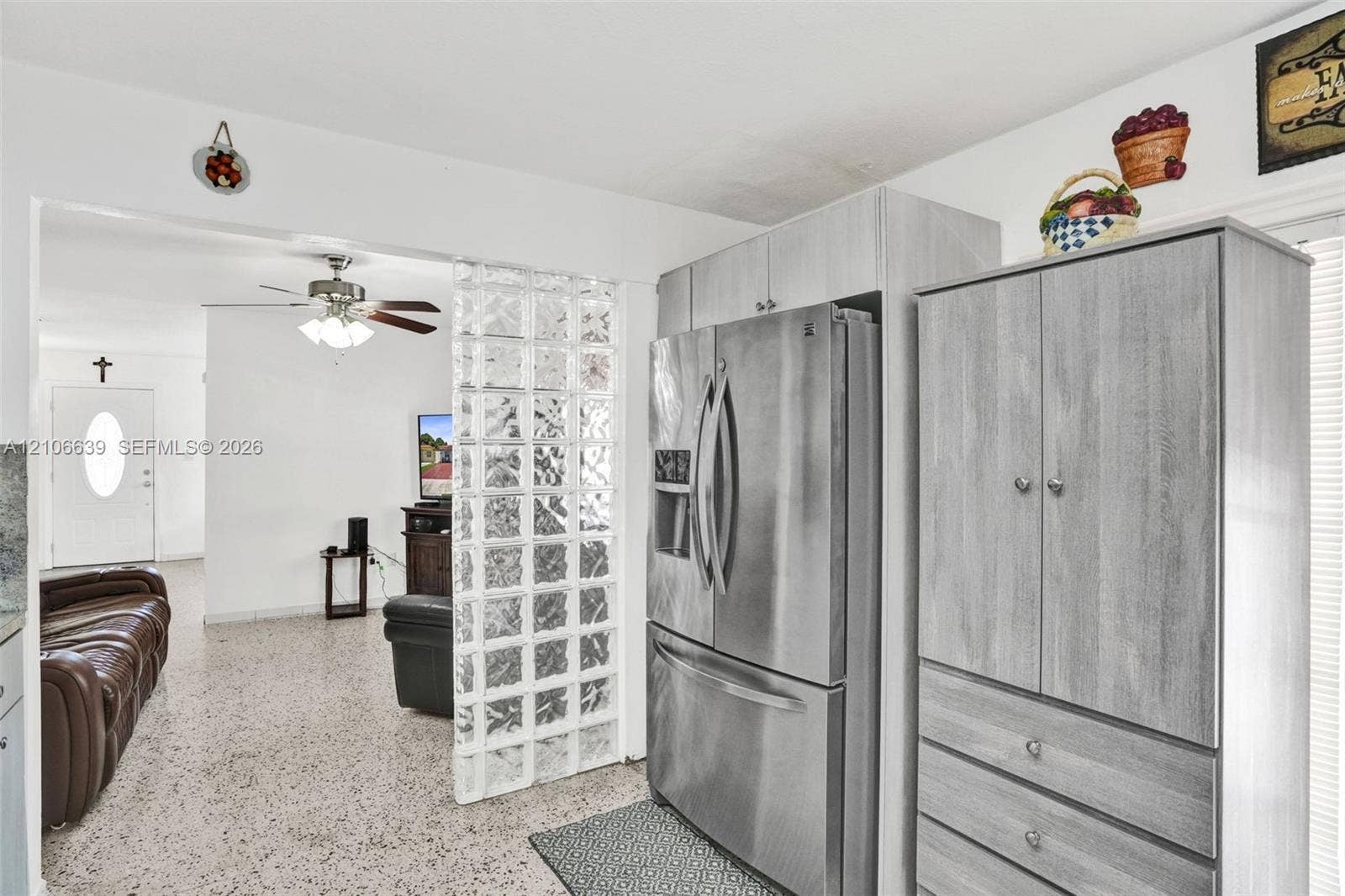 Glass block partition, stainless steel french-door refrigerator, and wood-finish cabinetry