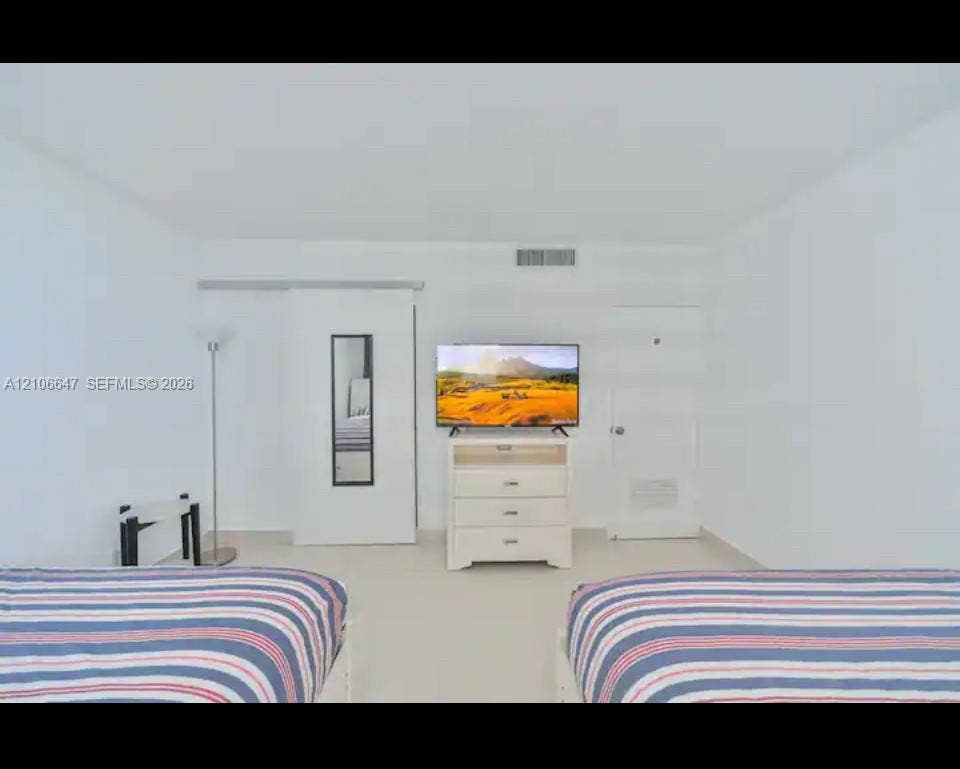 Room featuring neutral wall-to-wall flooring, a sliding door panel, and a solid-core interior door