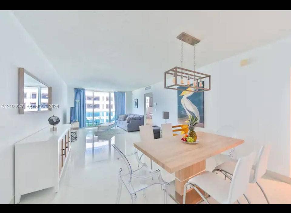 Open-concept living space featuring high-gloss tile flooring, floor-to-ceiling windows, and a structured metal-frame pendant light fixture
