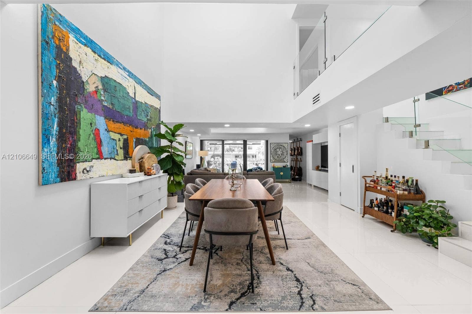 216 Poinciana Drive, #206, Sunny Isles Beach, FL 33160 Double-height ceilings, polished tile flooring, floating staircase with glass railings, recessed lighting, and expansive wall space