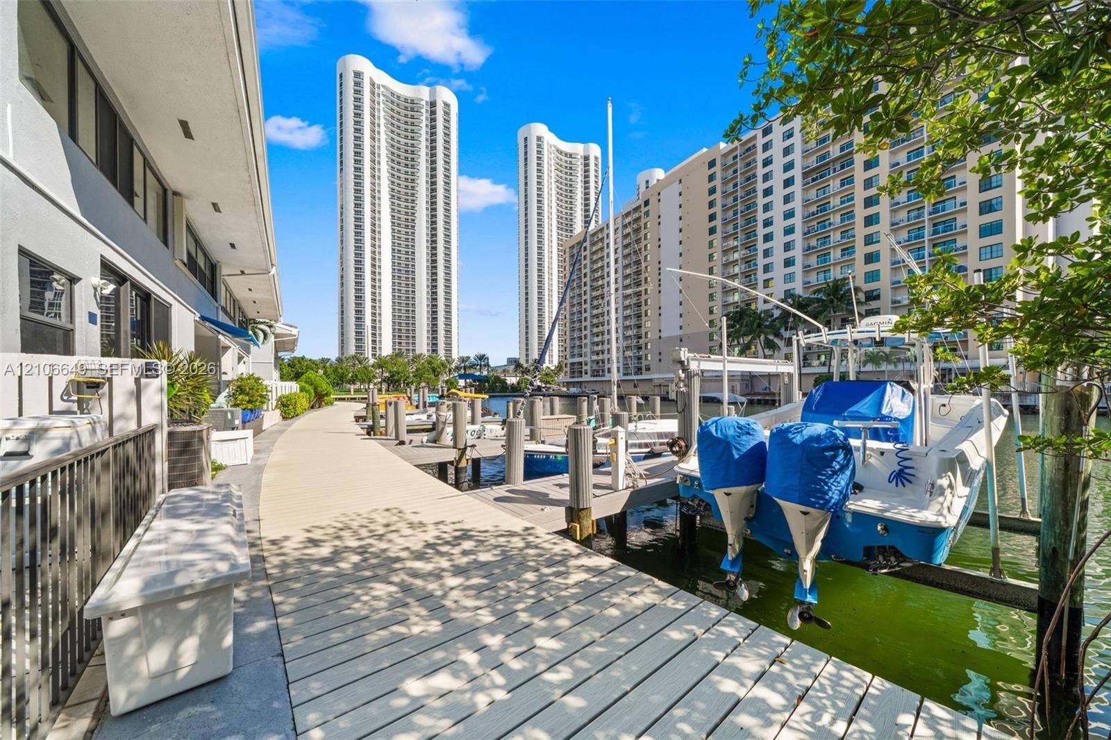 216 Poinciana Drive, #206, Sunny Isles Beach, FL 33160 Waterfront boardwalk featuring a private boat slip, concrete bulkhead, and industrial-grade pilings