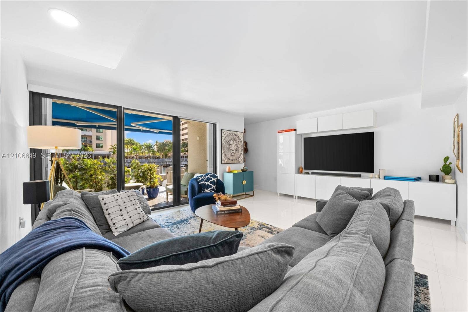 216 Poinciana Drive, #206, Sunny Isles Beach, FL 33160 Hallway featuring polished tile flooring, recessed lighting, and a bathroom equipped with a floating vanity, light-toned wood-finish cabinetry, and a stone-tiled accent wall