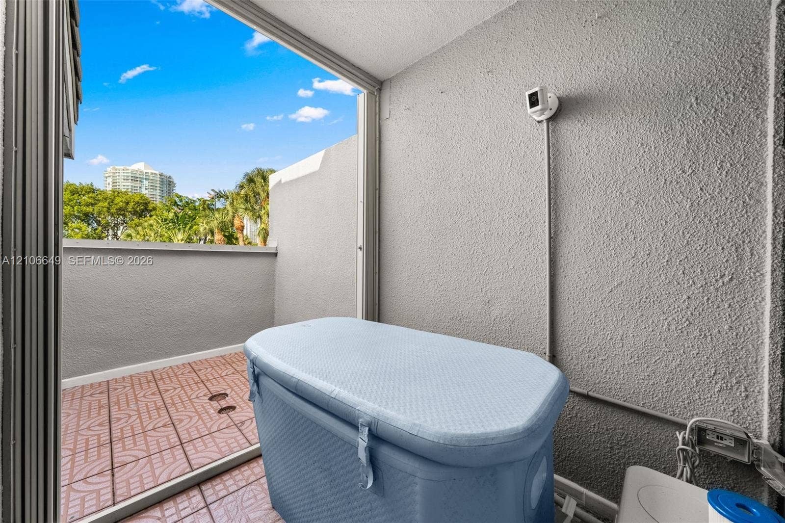216 Poinciana Drive, #206, Sunny Isles Beach, FL 33160 Private balcony featuring tiled flooring, a textured masonry wall, and a low-profile perimeter wall