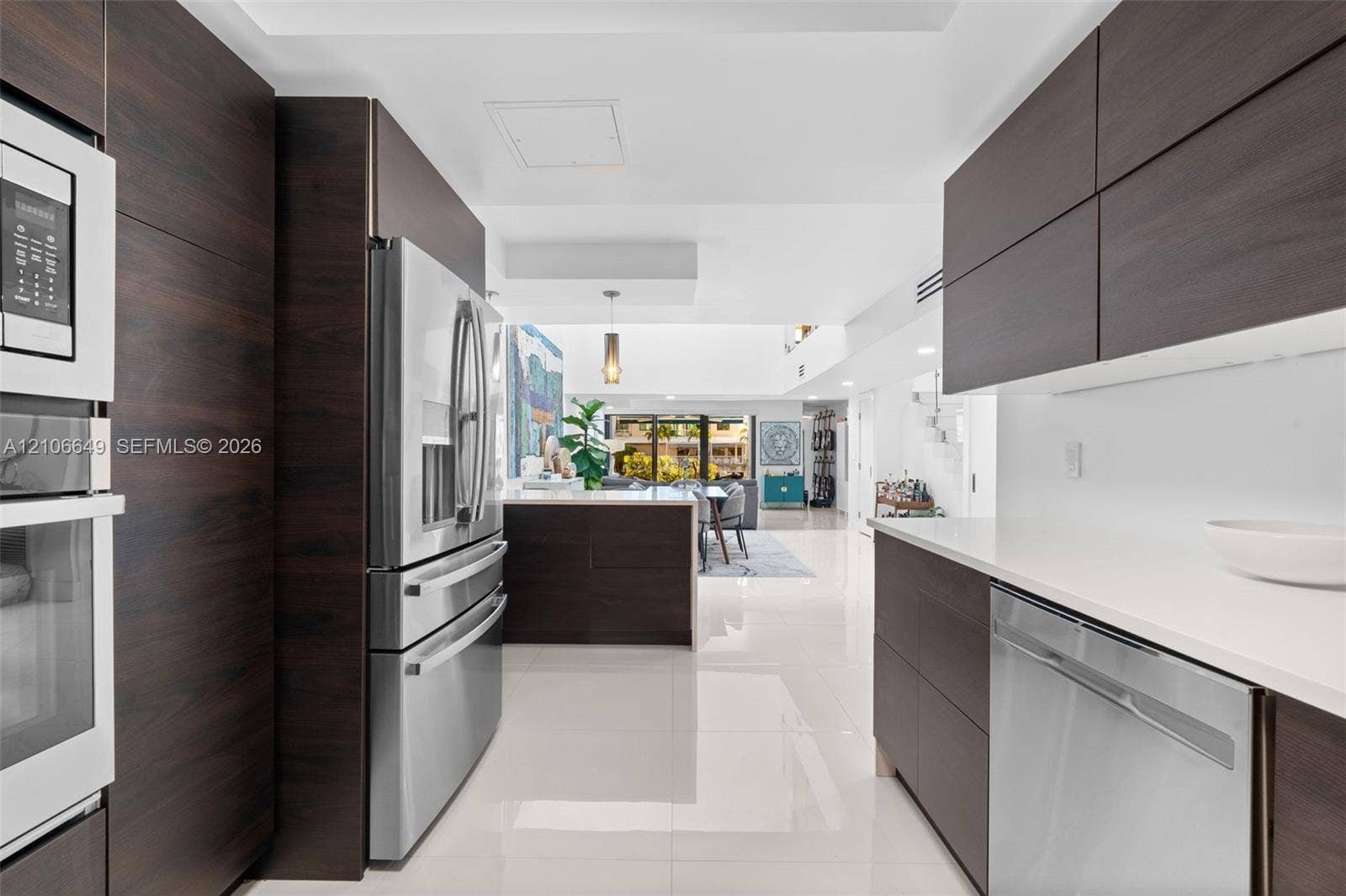 216 Poinciana Drive, #206, Sunny Isles Beach, FL 33160 Modern multi-level exterior featuring two attached garages, a herringbone-patterned paver driveway, and a recessed entryway with stone steps