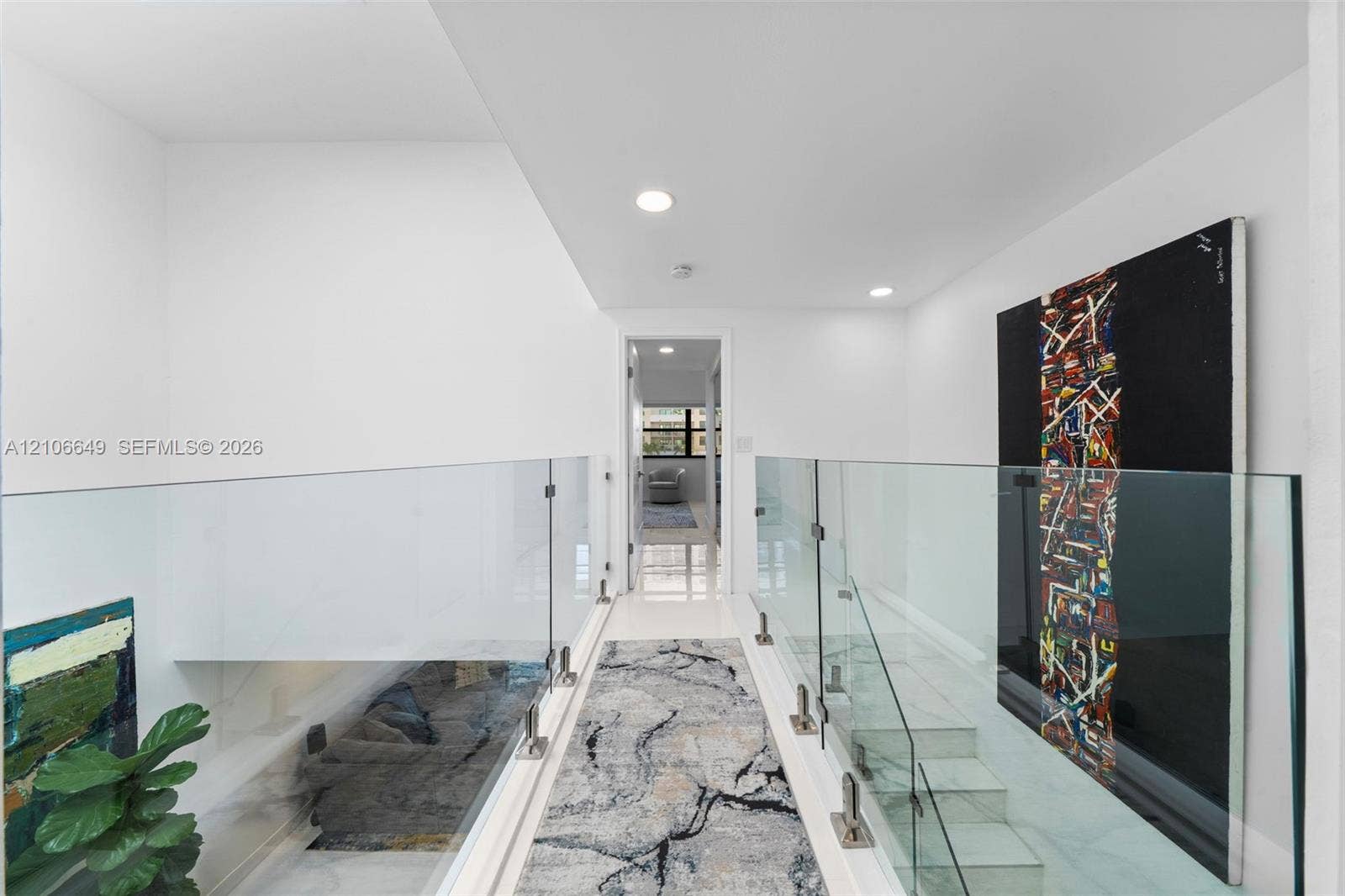 216 Poinciana Drive, #206, Sunny Isles Beach, FL 33160 Hallway featuring glass panel railings, metal hardware, stone-finish flooring, and recessed ceiling lighting