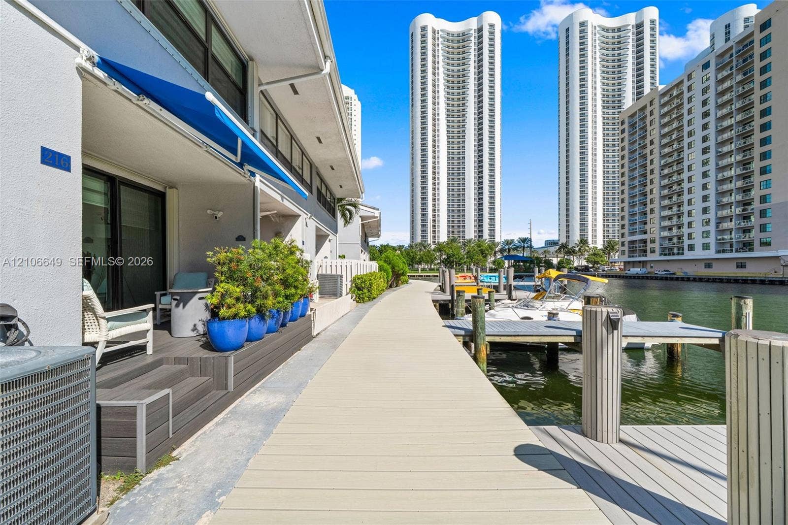 216 Poinciana Drive, #206, Sunny Isles Beach, FL 33160 Waterfront terrace featuring composite decking, an retractable fabric awning, and direct access to a private boat dock
