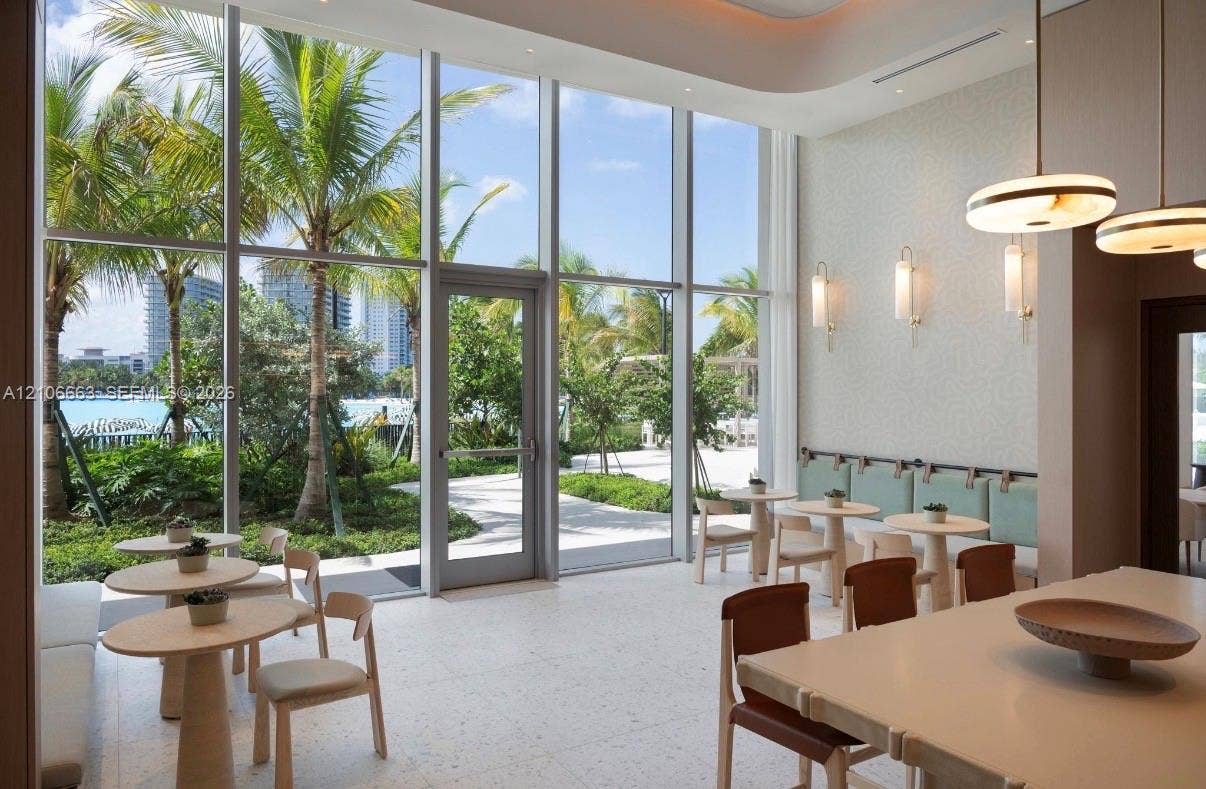 Floor-to-ceiling windows, light-toned terrazzo flooring, recessed lighting, and modern wall-mounted light fixtures