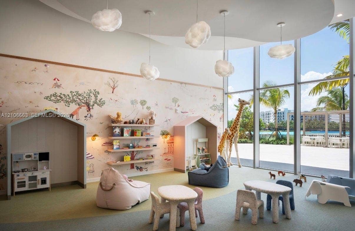 Floor-to-ceiling windows, custom built-in alcoves, patterned wall covering, recessed ceiling lighting with cloud-shaped pendants, and expansive carpeted flooring