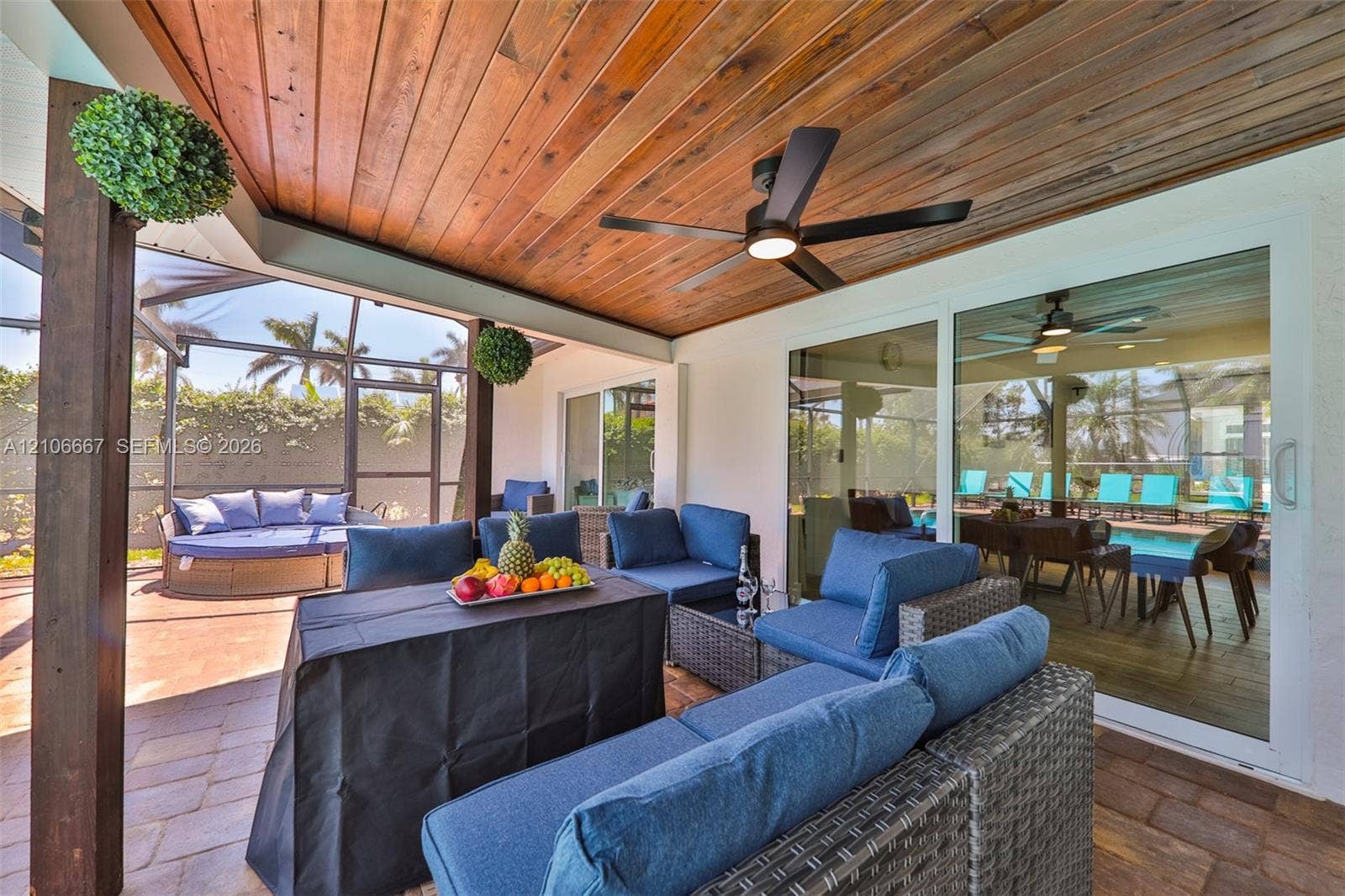 209 Bayshore Drive, Cape Coral, FL 33904 Covered patio featuring a wood-plank ceiling, ceiling fan, paver flooring, and a screened-in enclosure