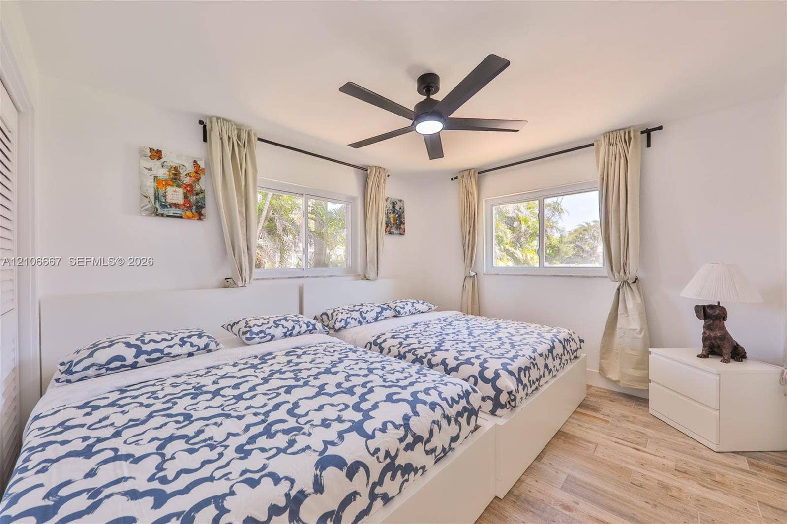 209 Bayshore Drive, Cape Coral, FL 33904 Bedroom featuring wood-finish flooring, dual windows, and a ceiling fan with integrated lighting
