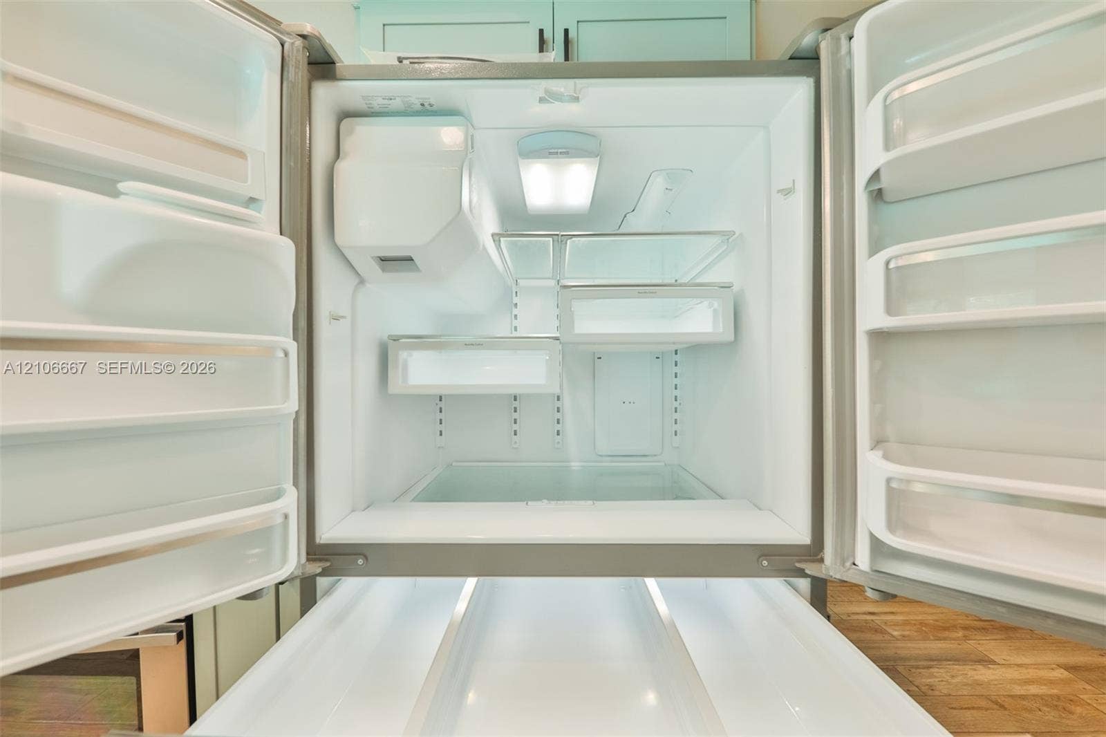 209 Bayshore Drive, Cape Coral, FL 33904 French-door refrigerator featuring adjustable shelving, integrated interior LED lighting, multiple door-mounted storage bins, and a sliding pull-out freezer drawer