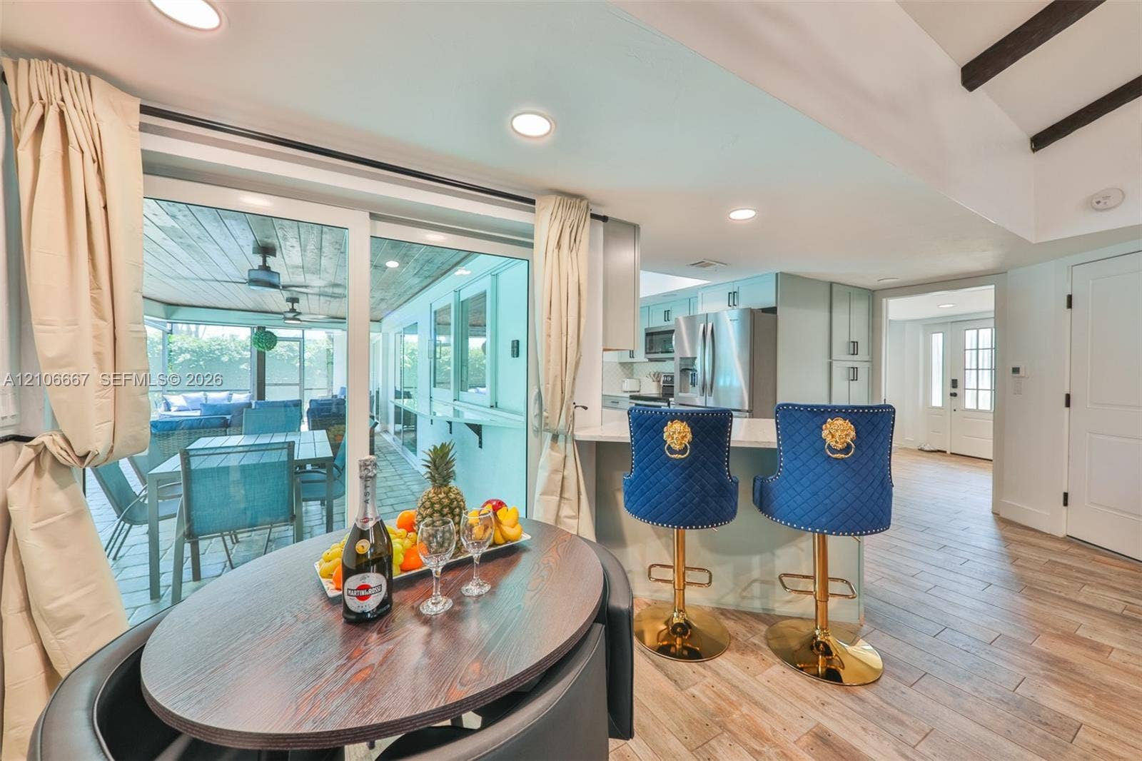209 Bayshore Drive, Cape Coral, FL 33904 Kitchen featuring wood-finish tile flooring, recessed lighting, white cabinetry, and a stone-surface peninsula with integrated seating