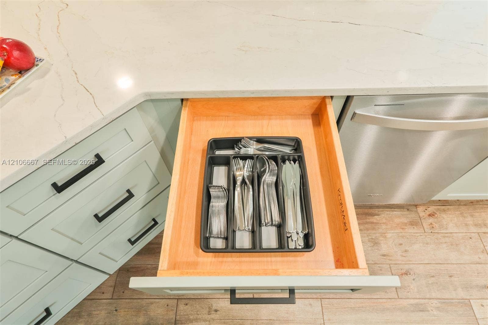 209 Bayshore Drive, Cape Coral, FL 33904 Custom-built wooden drawer with dovetailed joinery, integrated cabinetry with matte black hardware, and stone countertop with veined patterning