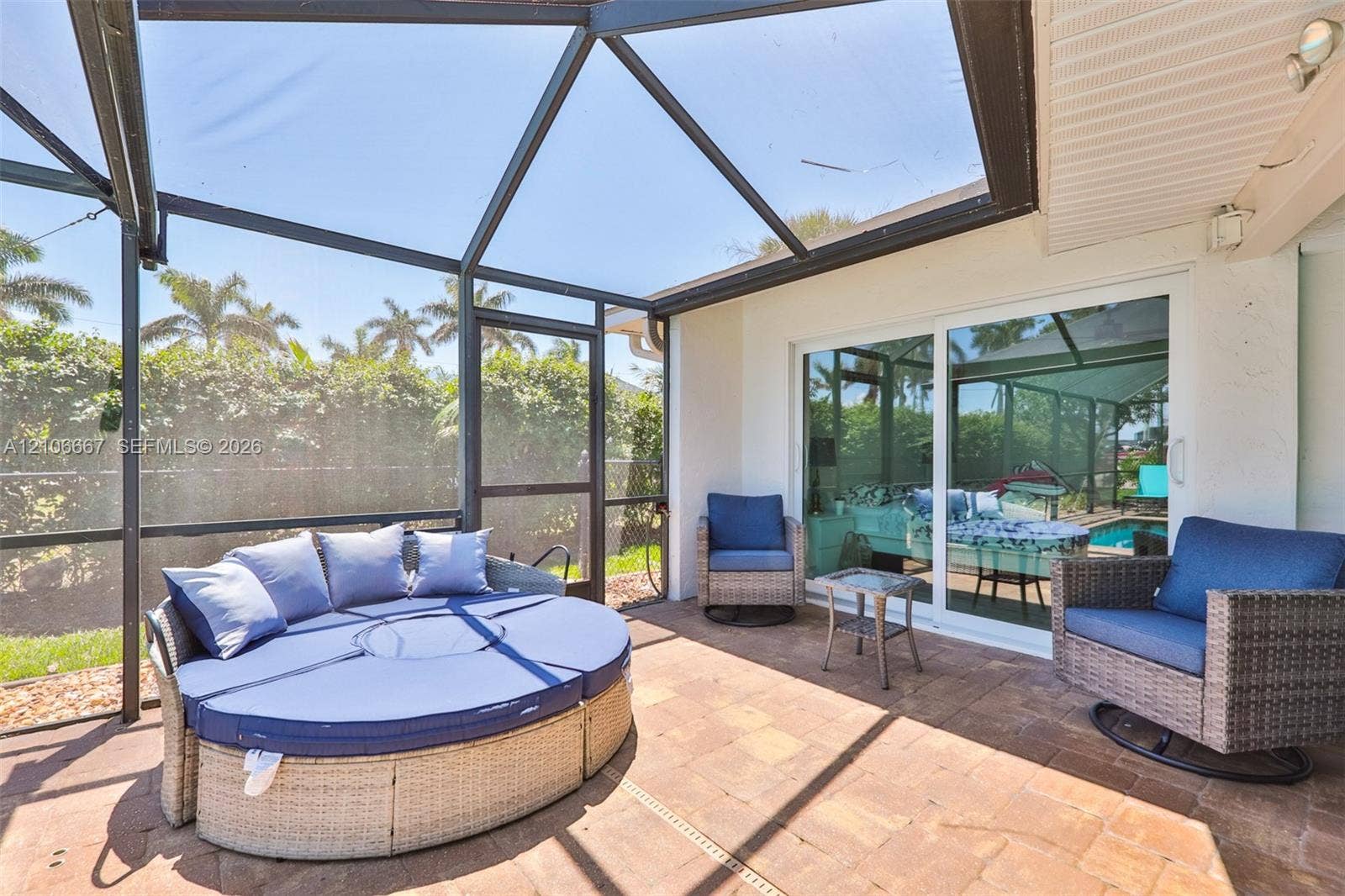 209 Bayshore Drive, Cape Coral, FL 33904 Screened-in lanai featuring paver flooring, a dark-frame enclosure, and large glass sliding doors