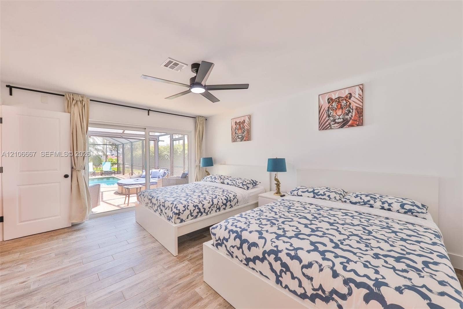 209 Bayshore Drive, Cape Coral, FL 33904 Neutral interior featuring wood-finish flooring, a contemporary multi-blade ceiling fan, and large sliding glass doors providing outdoor access
