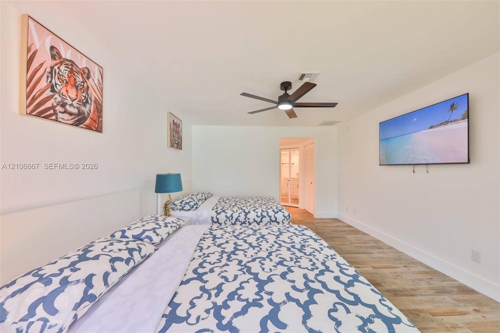 209 Bayshore Drive, Cape Coral, FL 33904 Spacious room featuring wood-finish flooring, a ceiling fan with integrated lighting, and white walls