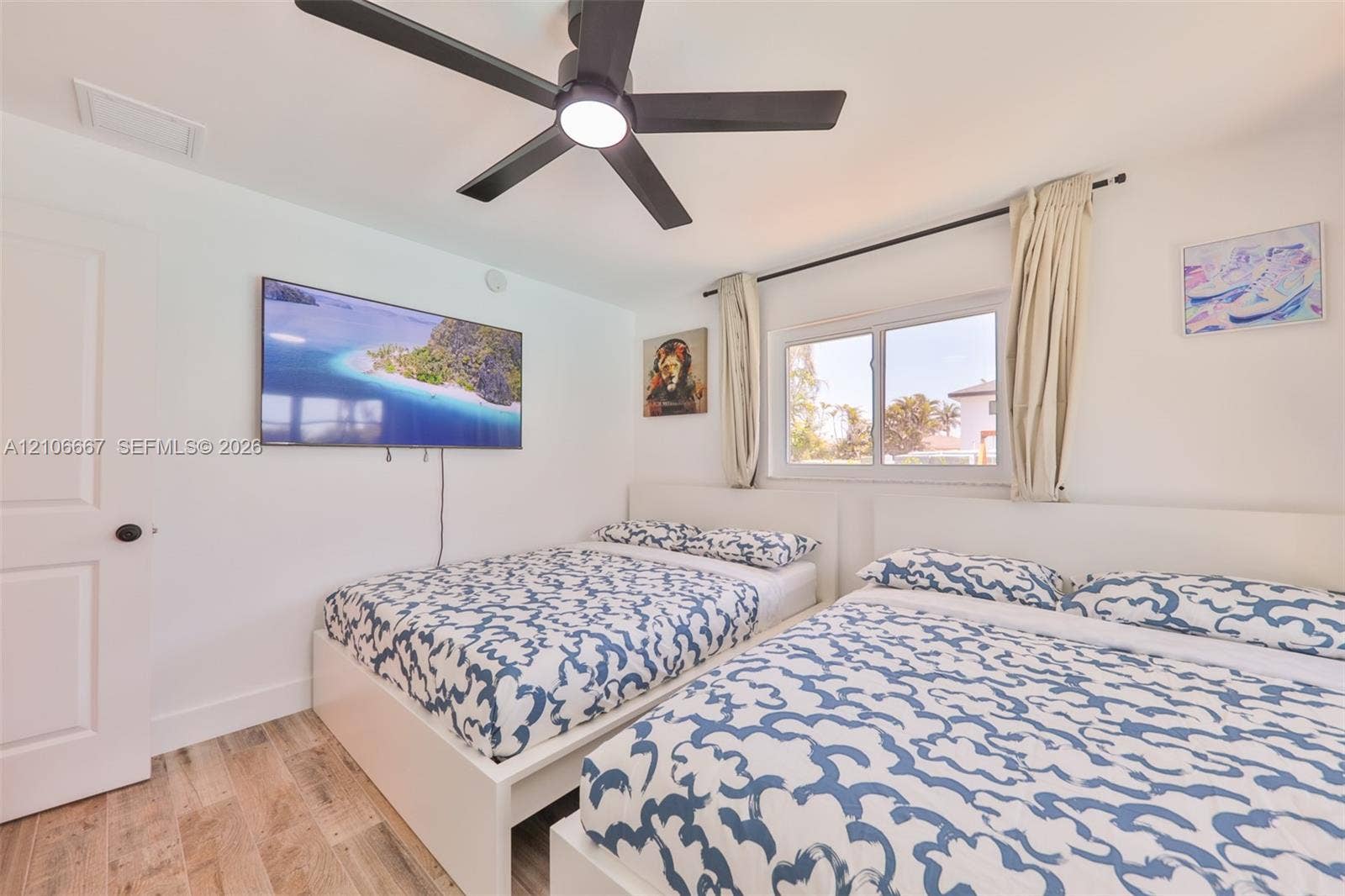 209 Bayshore Drive, Cape Coral, FL 33904 Wood-finish flooring, neutral walls, and a ceiling-mounted matte black fan with integrated lighting