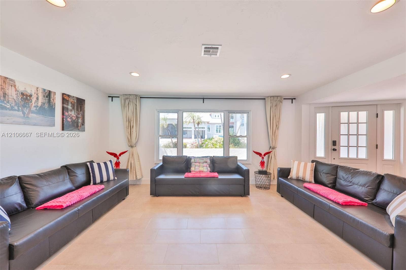 209 Bayshore Drive, Cape Coral, FL 33904 Open-concept space featuring large-format tile flooring, recessed lighting, a central picture window, and a multi-pane entry door with sidelights