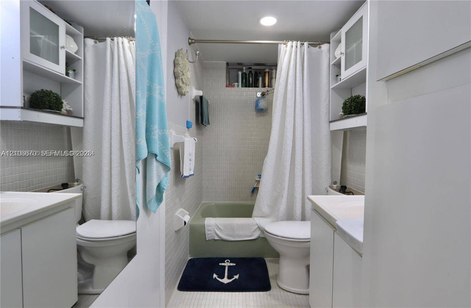 3030 Marcos Drive, #T512, Aventura, FL 33160 Bathroom featuring dual white cabinetry with integrated sinks, recessed ceiling lighting, a bathtub-shower combination with full-height wall tiling, and built-in upper shelving