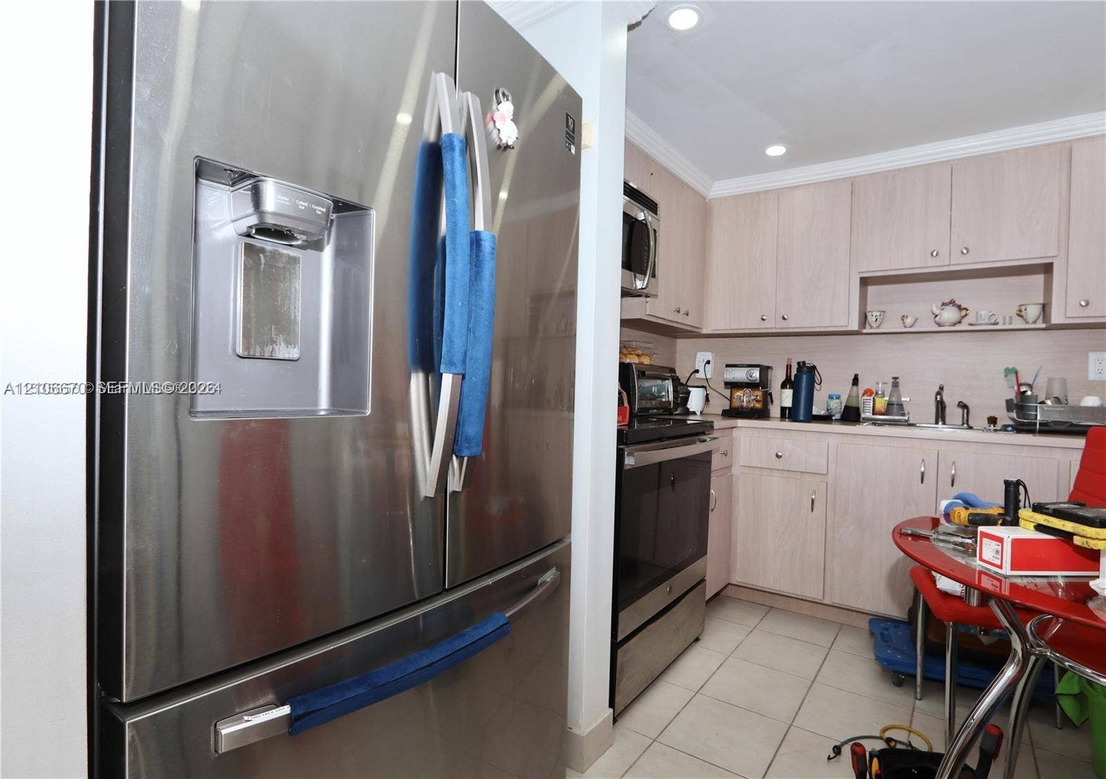 3030 Marcos Drive, #T512, Aventura, FL 33160 Stainless steel French-door refrigerator, light wood-finish cabinetry, recessed ceiling lighting, and ceramic tile flooring