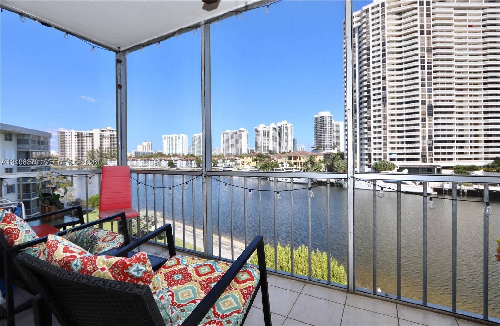 3030 Marcos Drive, #T512, Aventura, FL 33160 Screened-in balcony featuring tile flooring and metal railings overlooking the waterway