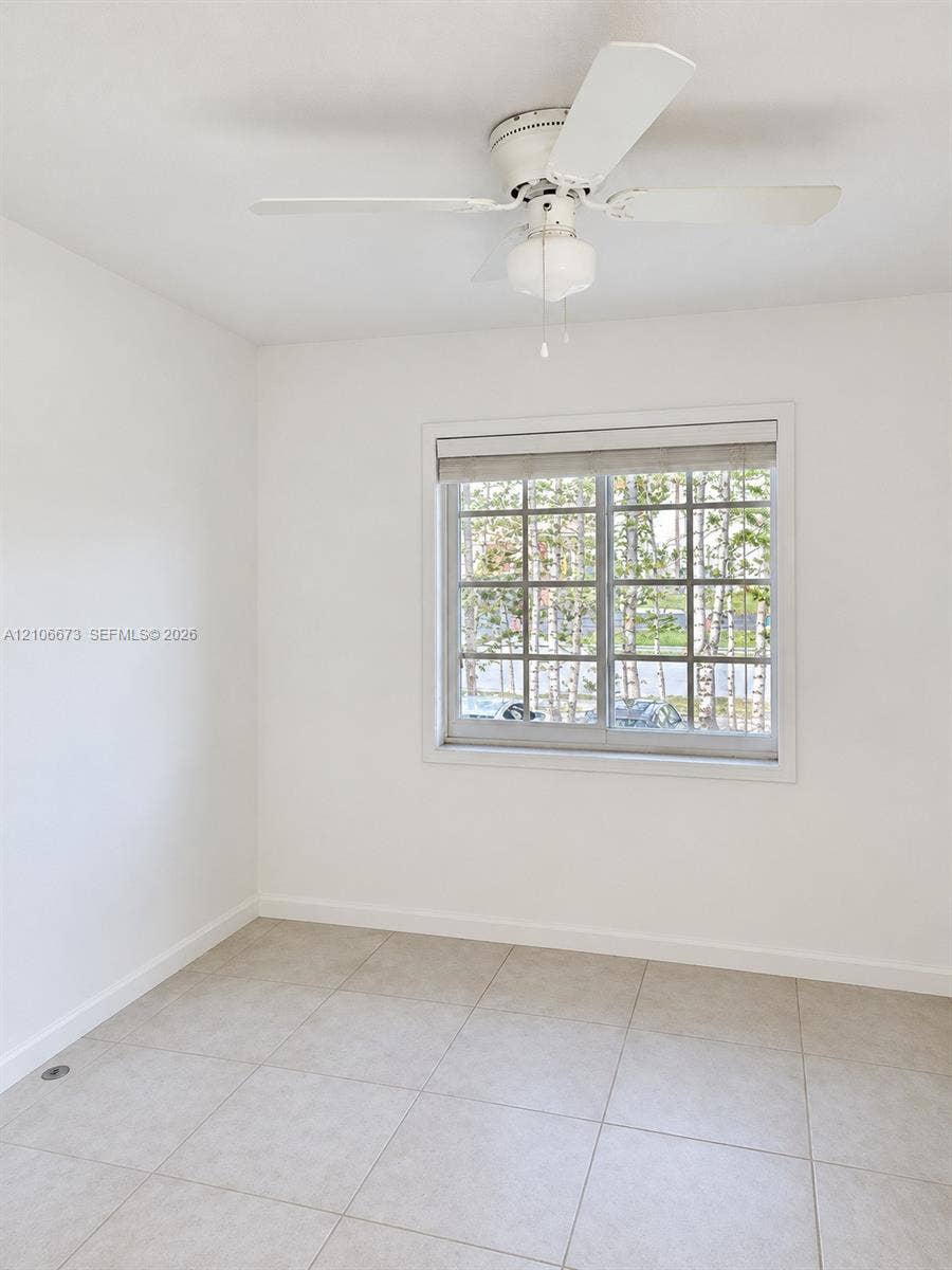 704 SE 2nd Avenue, #440, Deerfield Beach, Deerfield Beach, FL 33441 Neutral-toned tile flooring, white ceiling fan with integrated lighting, and a multi-pane window featuring a window shade