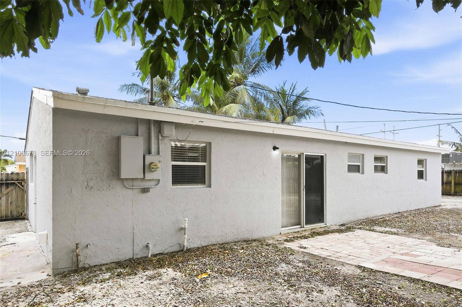 7060 Hood Street, Hollywood, Hollywood, FL 33024 Stucco exterior, sliding glass door, paved patio, and multiple horizontal slider windows
