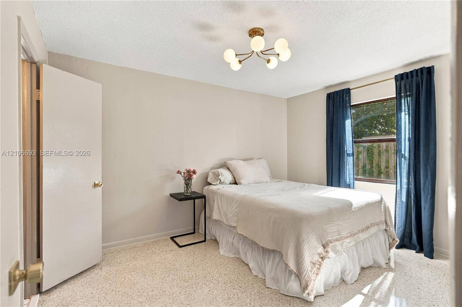 1459 42nd Street, West Palm Beach, FL 33407 Neutral wall palette with terrazzo flooring, six-light globe-style chandelier, and a wide-set window