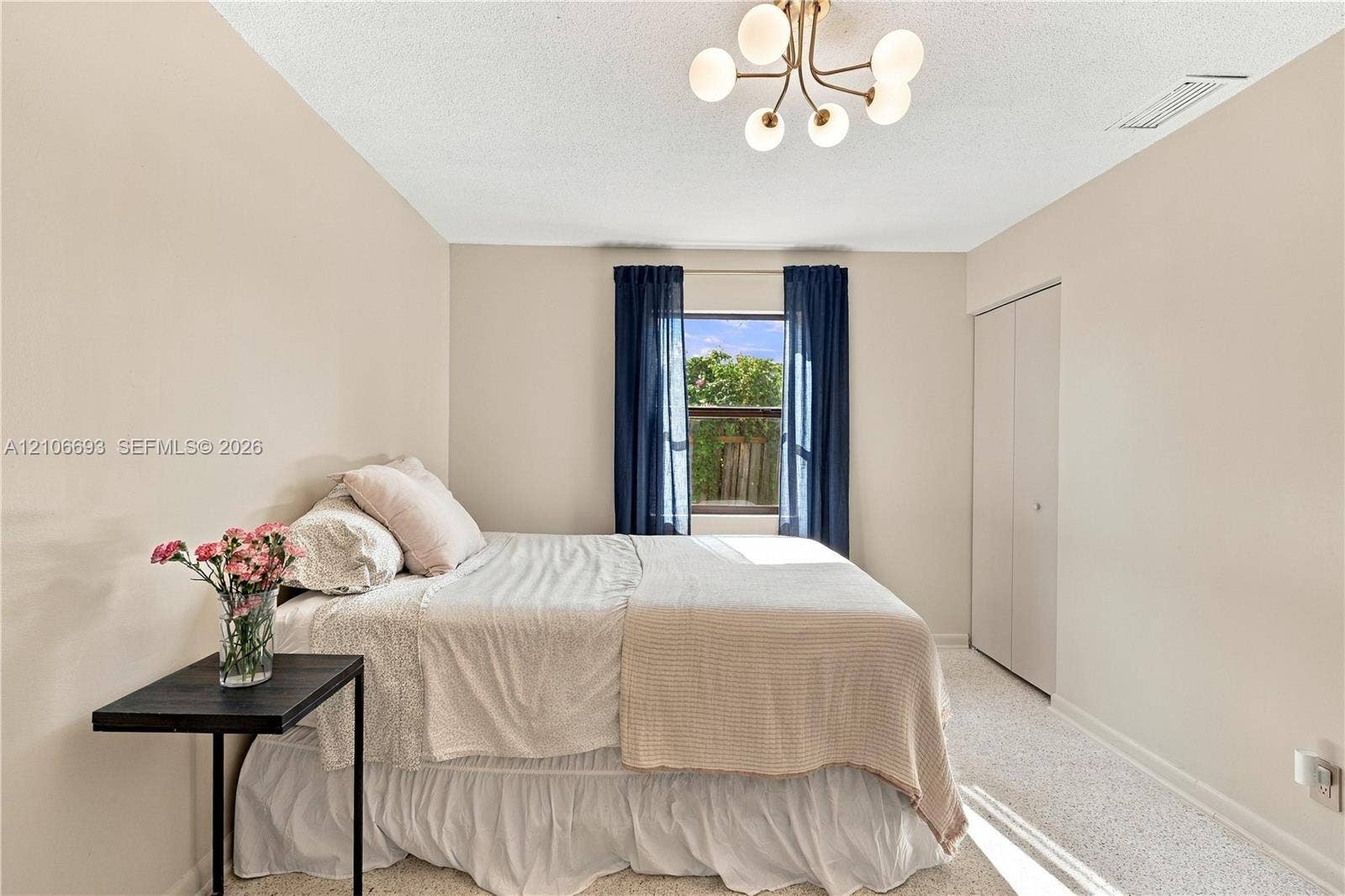 1459 42nd Street, West Palm Beach, FL 33407 Neutral-toned walls, multi-arm light fixture with frosted glass globes, carpeted flooring, and reach-in closet with double doors