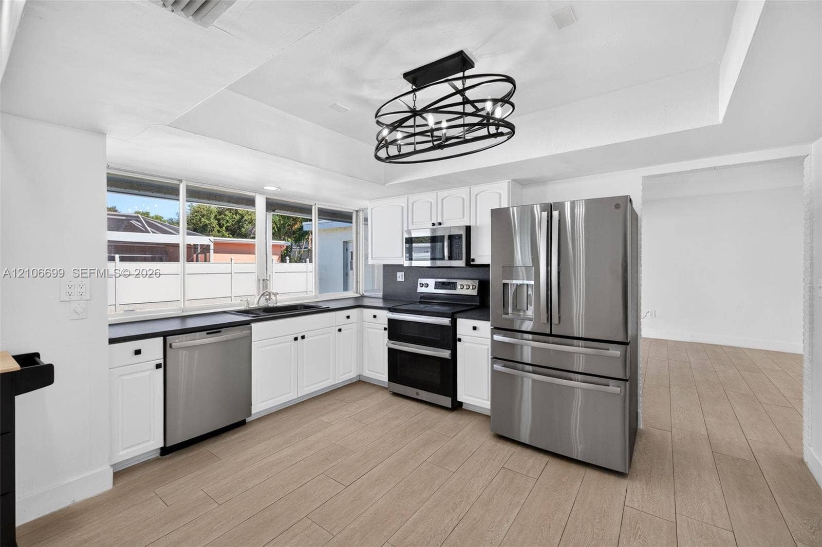 9121 SW 54th Place, Cooper City, FL 33328 Open concept kitchen w/ updated plank wood look tile, stainless appliances approx 2020