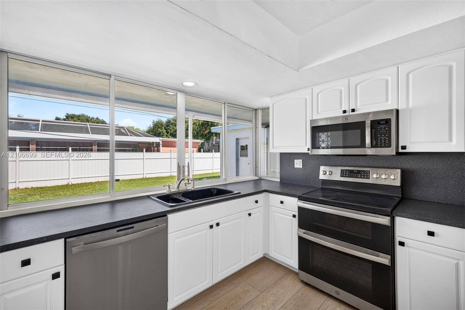 9121 SW 54th Place, Cooper City, FL 33328 Open concept kitchen w/ updated plank wood look tile, stainless appliances approx 2020