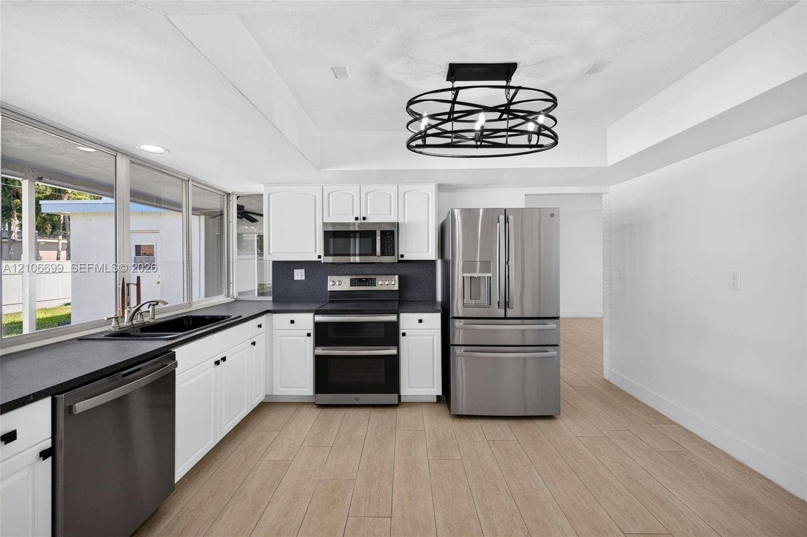 9121 SW 54th Place, Cooper City, FL 33328 Open concept kitchen w/ updated plank wood look tile, stainless appliances approx 2020