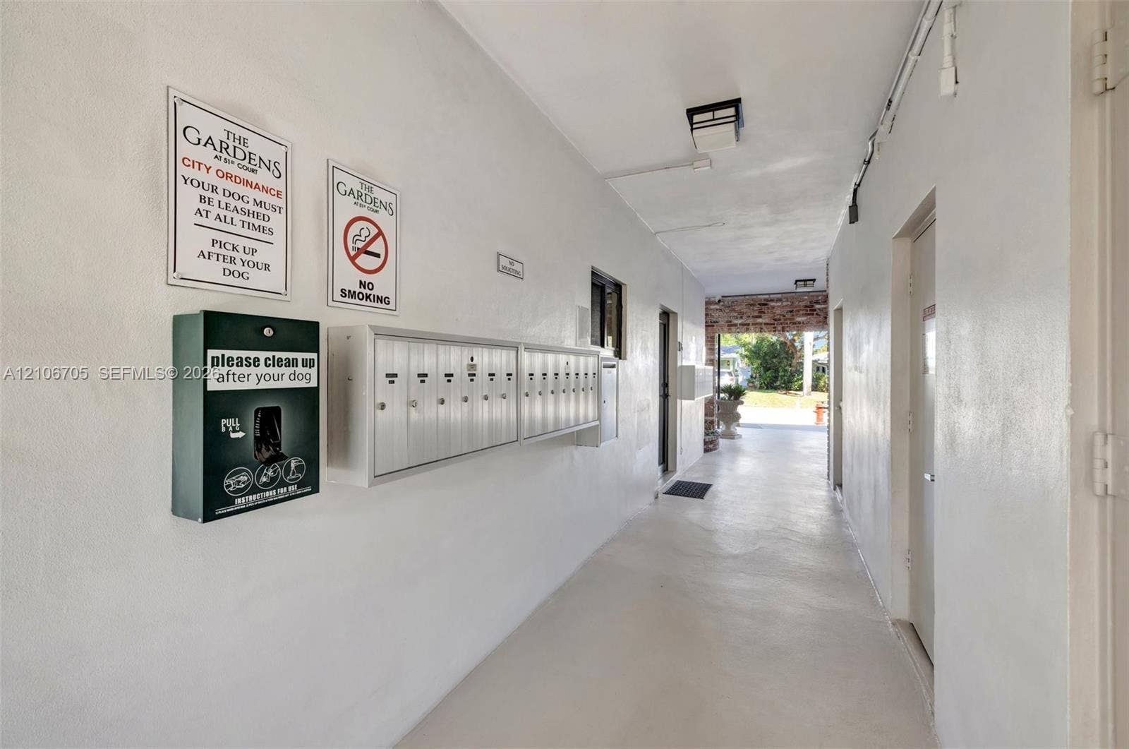 Covered breezeway featuring a wall-mounted metal mailbox bank and exterior lighting fixture