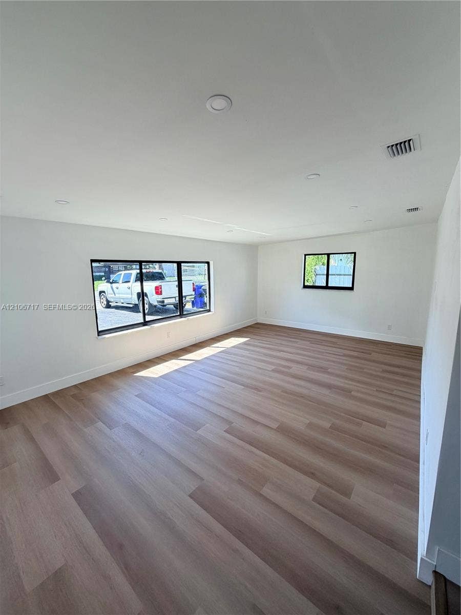 6811 Thomas Street, Hollywood, FL 33024 Interior space featuring light-toned wood-finish flooring, recessed lighting, and black-framed windows