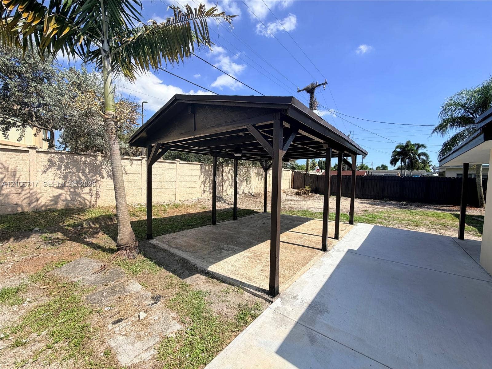 6811 Thomas Street, Hollywood, FL 33024 Covered gazebo featuring a dark-finish wood frame, concrete foundation, and high-contrast roof, situated within a fenced exterior space