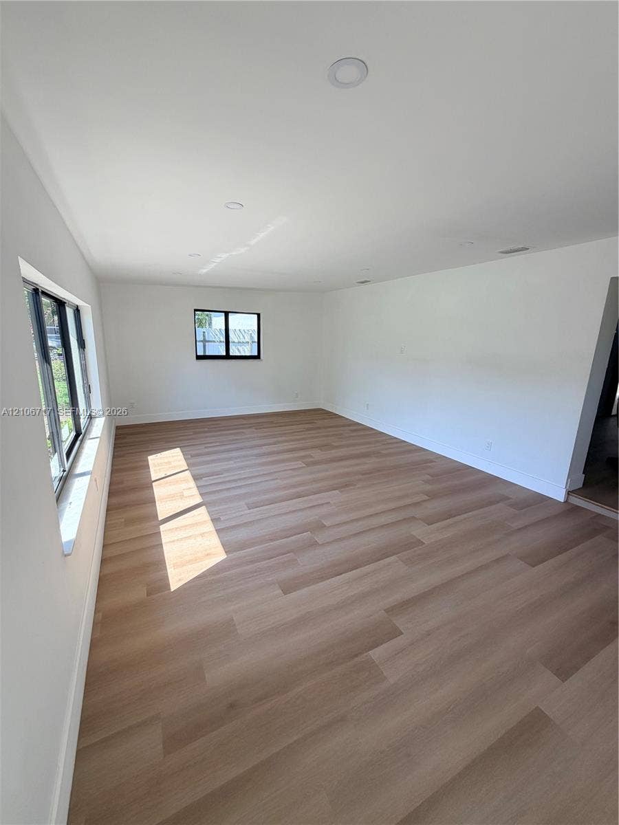 6811 Thomas Street, Hollywood, FL 33024 Neutral interior space featuring wood-finish flooring, recessed lighting, and black-framed windows