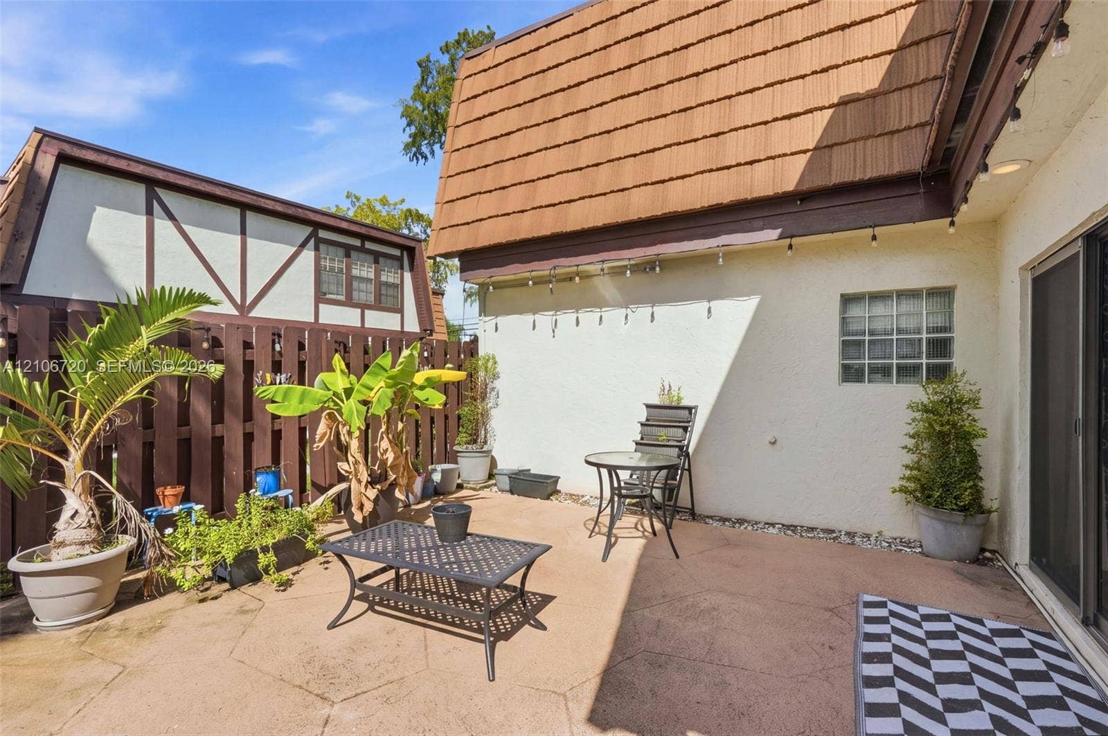 152 Weybridge Circle, #C, Royal Palm Beach, FL 33411 Private rear patio featuring stamped concrete flooring, a block wall fence, and a glass block window