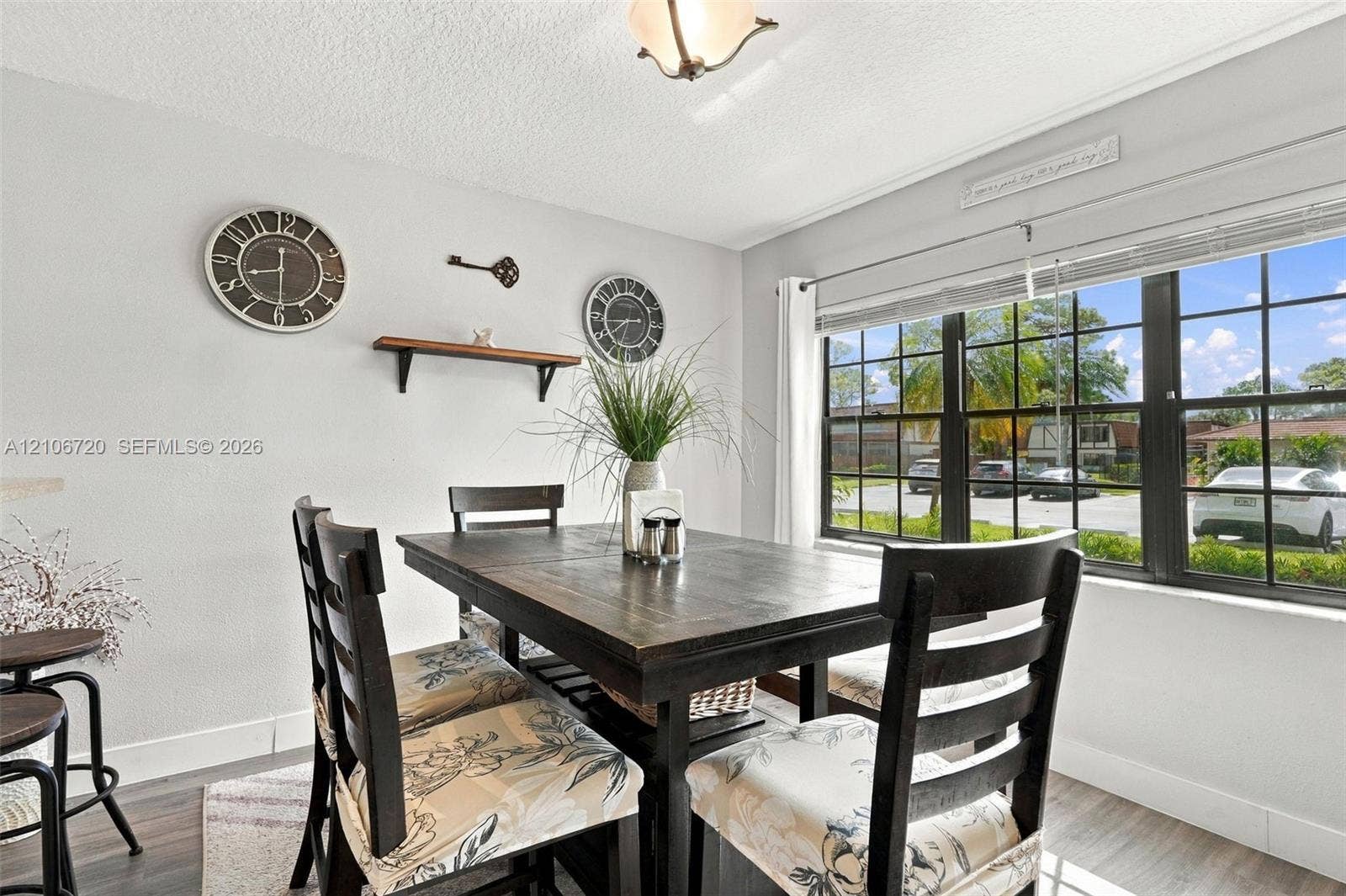 152 Weybridge Circle, #C, Royal Palm Beach, FL 33411 Neutral-toned walls featuring a natural wood-finish floating shelf, grid-patterned windows, and a flush-mount light fixture