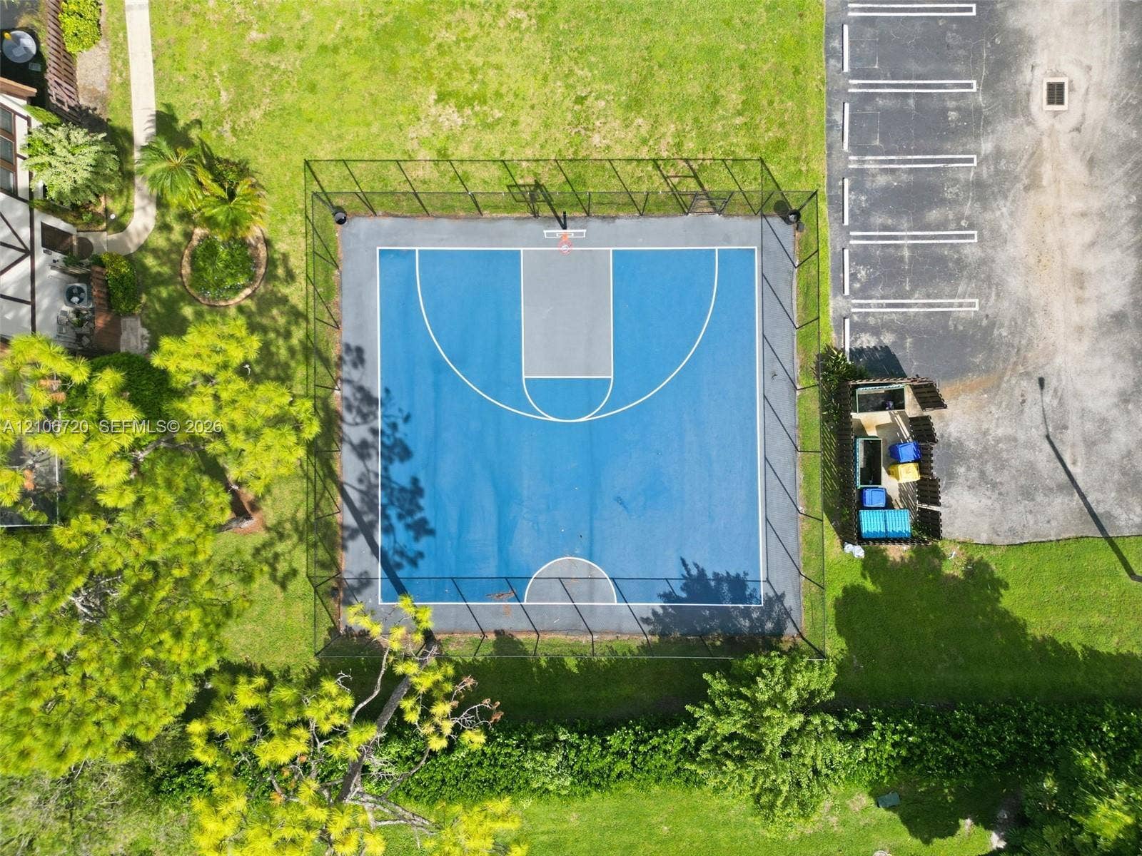 152 Weybridge Circle, #C, Royal Palm Beach, FL 33411 Fenced basketball court featuring a multi-tone blue hard surface, permanent hoop assembly, and perimeter chain-link enclosure