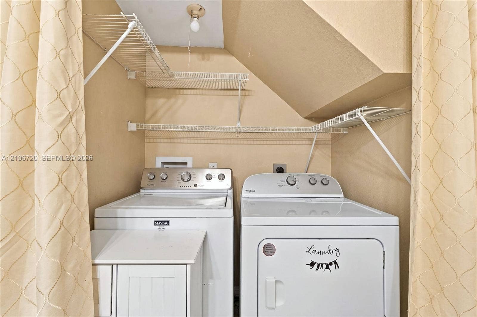 152 Weybridge Circle, #C, Royal Palm Beach, FL 33411 Laundry area featuring white wire shelving, a ceiling-mounted light fixture, and a built-in white cabinet unit