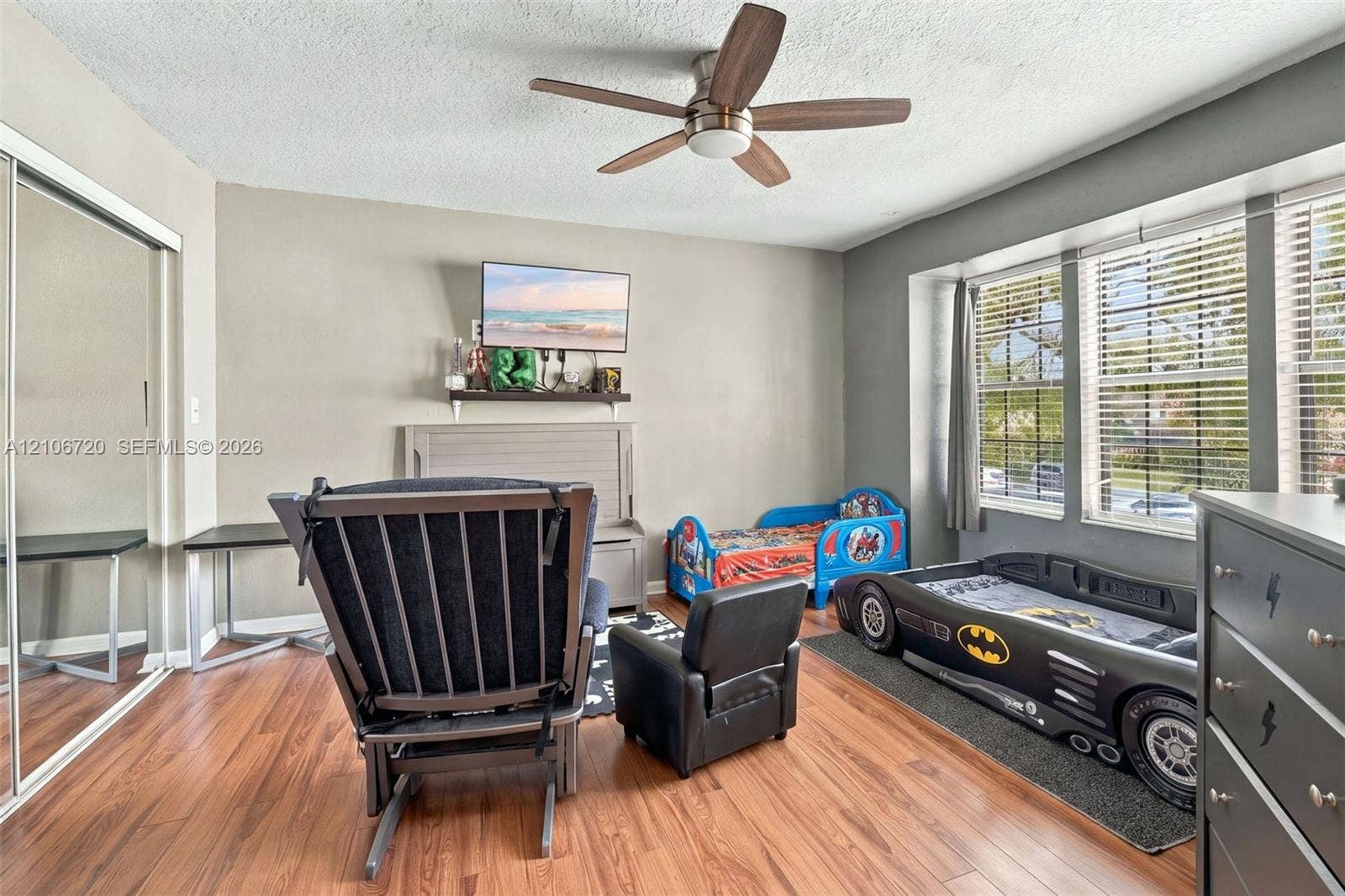 152 Weybridge Circle, #C, Royal Palm Beach, FL 33411 Wood-finish flooring, ceiling fan with integrated lighting, mirrored sliding-door closet, and large multi-pane windows with horizontal blinds