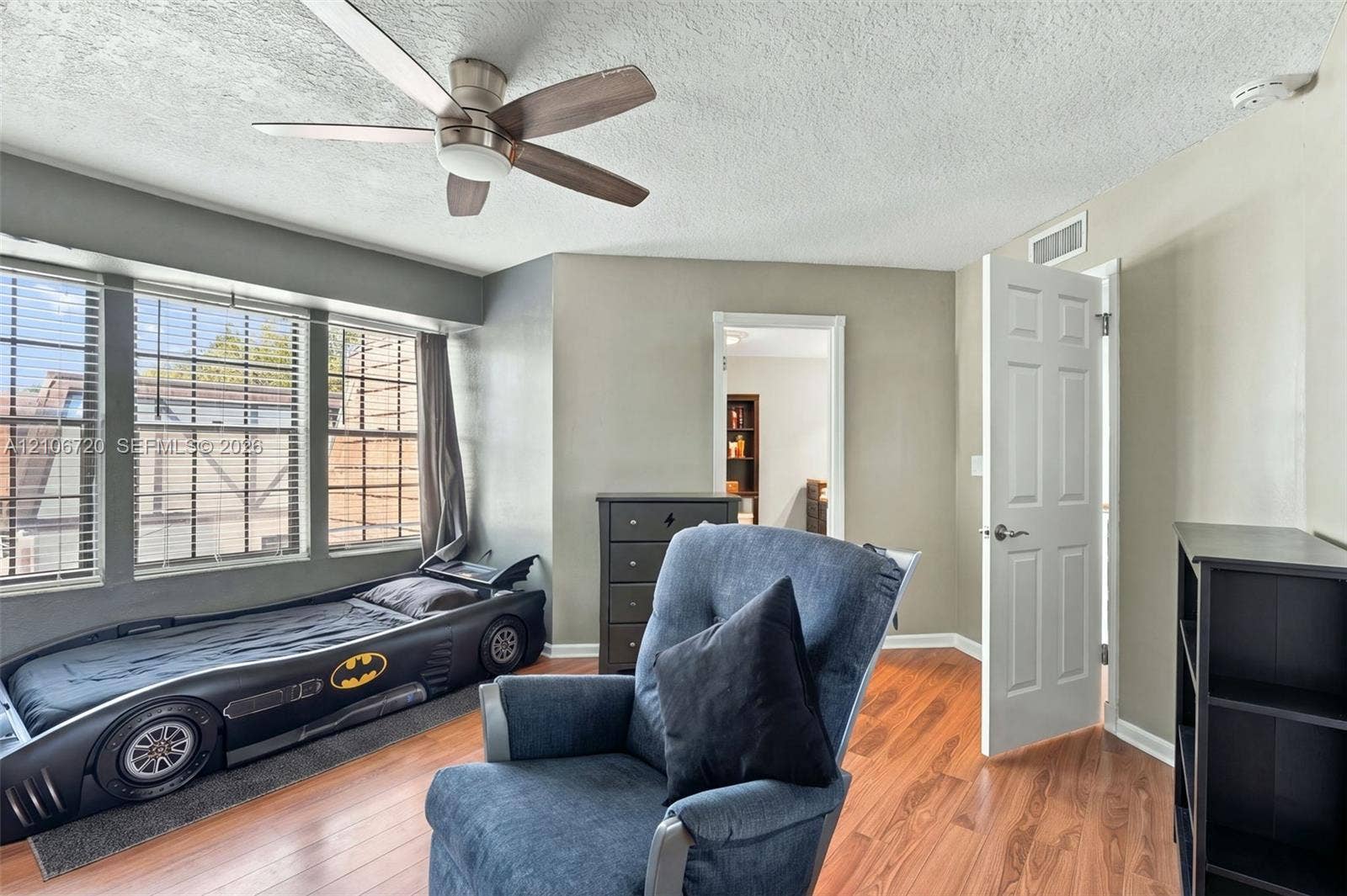 152 Weybridge Circle, #C, Royal Palm Beach, FL 33411 Room featuring wood-finish flooring, a multi-pane bay window, and a ceiling fan with integrated lighting