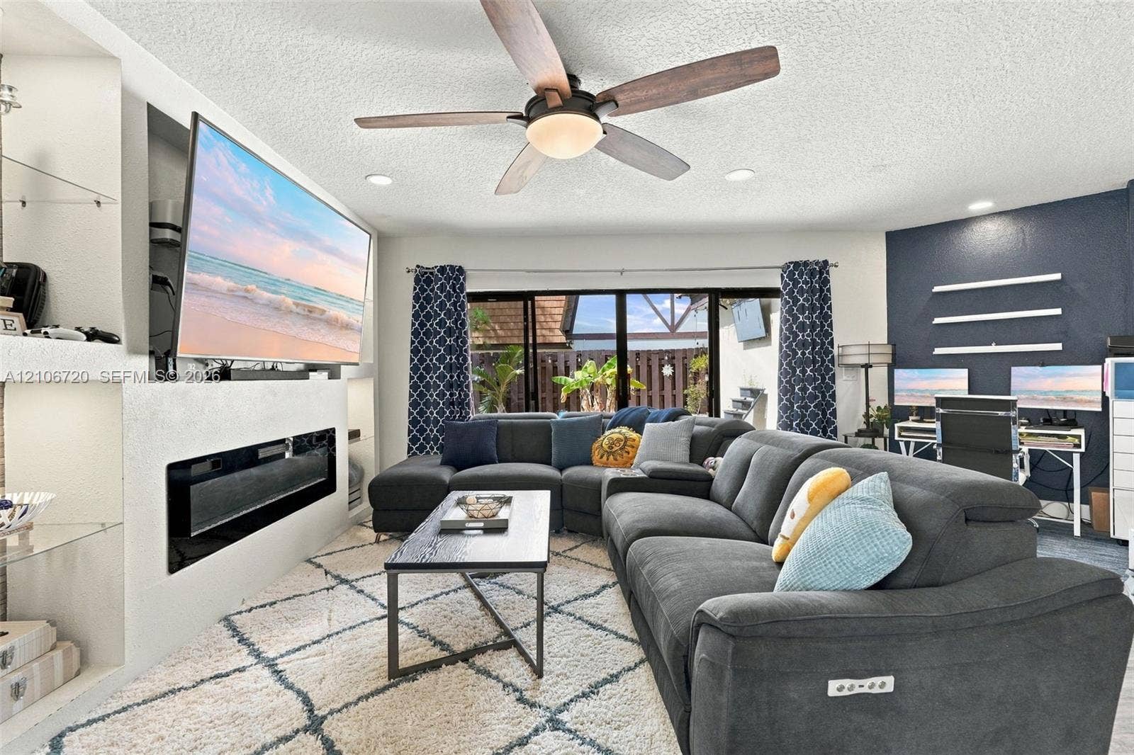 152 Weybridge Circle, #C, Royal Palm Beach, FL 33411 Living area featuring a recessed fireplace with built-in shelving, a centrally mounted ceiling fan, recessed lighting, and expansive floor-to-ceiling glass sliding doors
