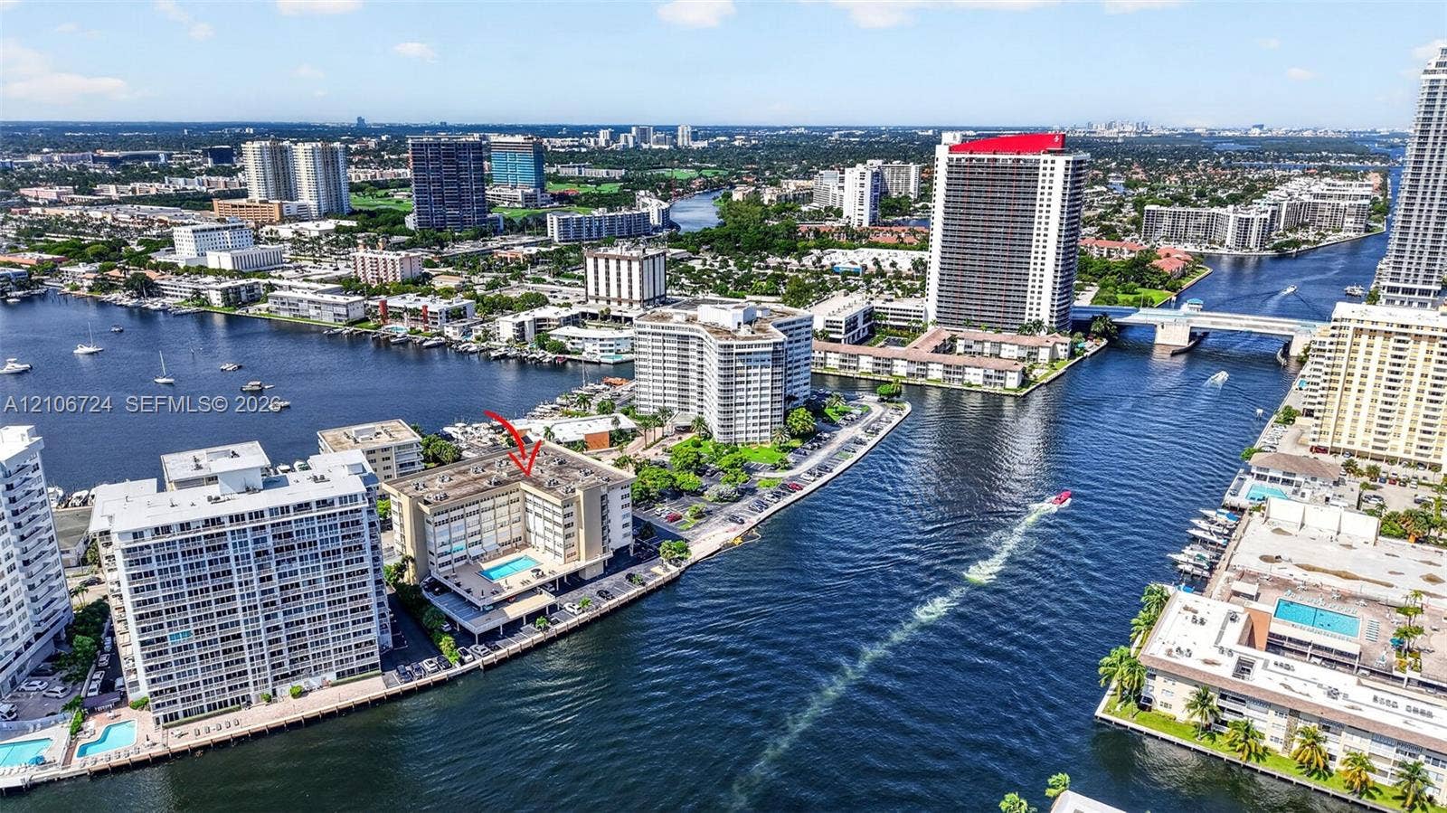 111 Golden Isles Drive, #G12, Hallandale Beach, FL 33009 Waterfront mid-rise building featuring a ground-level pool, surface parking, and direct maritime canal access