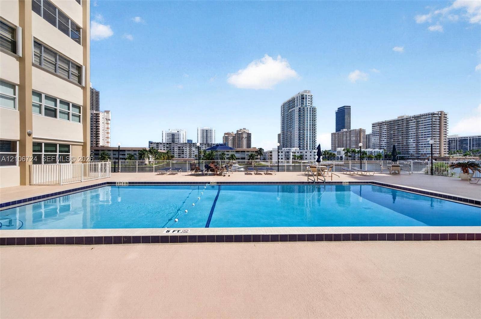 111 Golden Isles Drive, #G12, Hallandale Beach, FL 33009 Rectangular swimming pool featuring a tiled perimeter, integrated lane marker, and surround with water-front exposure