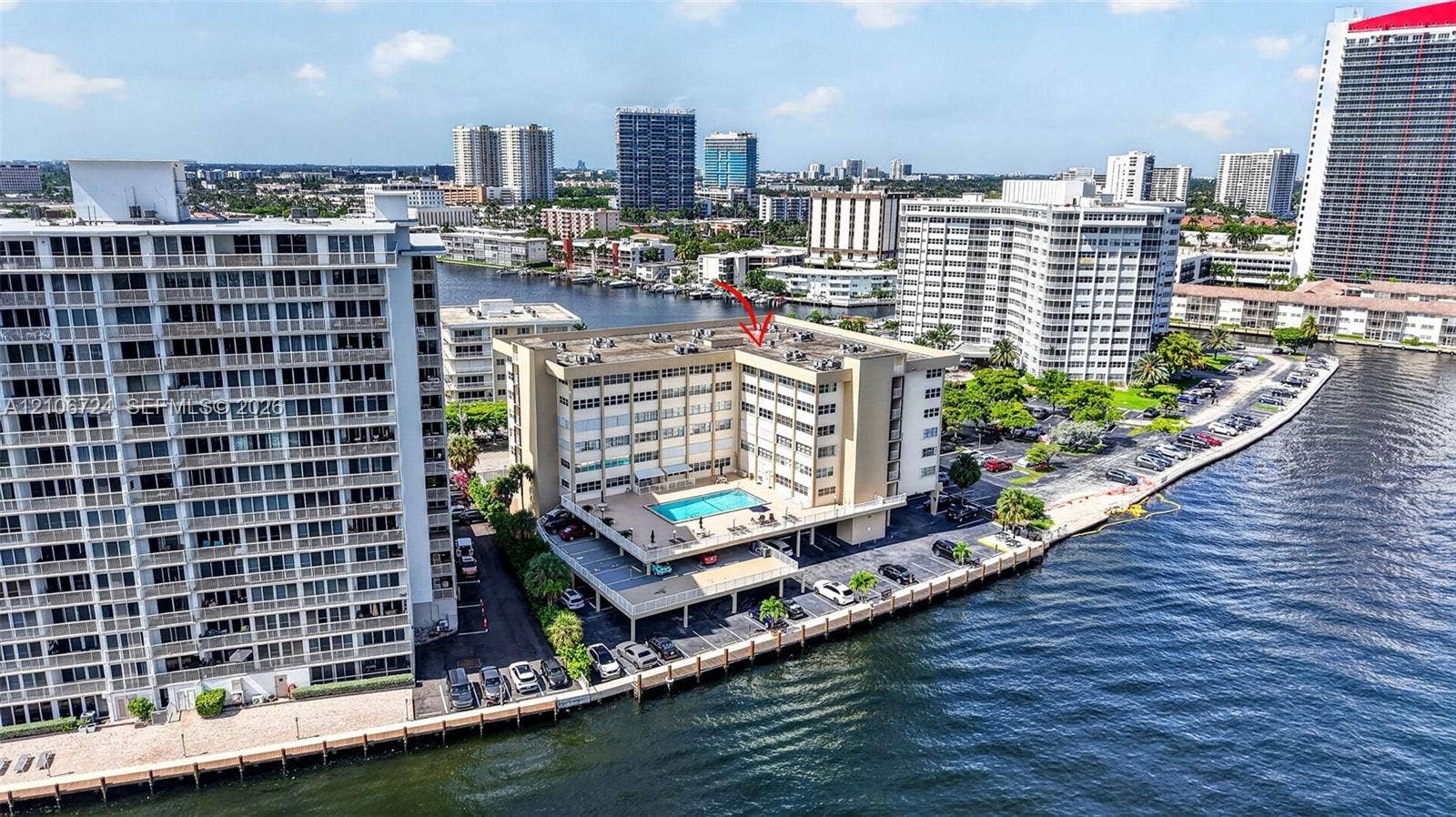 111 Golden Isles Drive, #G12, Hallandale Beach, FL 33009 Mid-rise waterfront building featuring a rooftop swimming pool and direct bulkhead access
